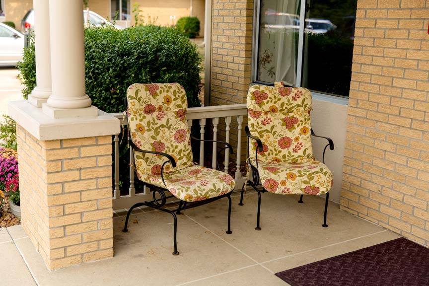 Exterior shot of two porch chairs at the Carrier Mills Nursing and Rehabilitation Center, from the Carrier Mills Gallery